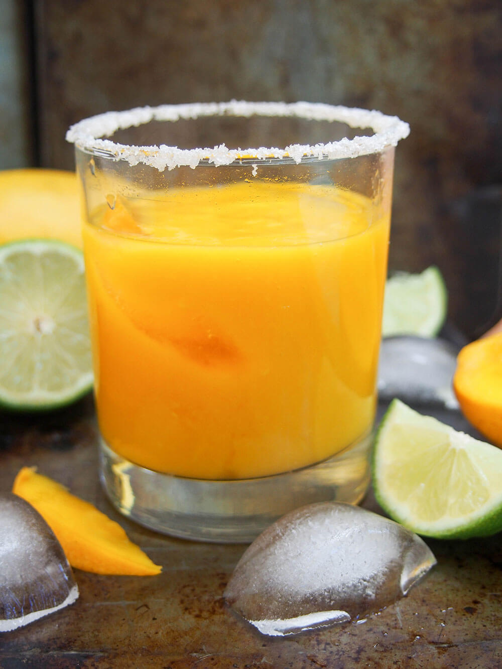 mango margarita glass from side with ice cubes in front
