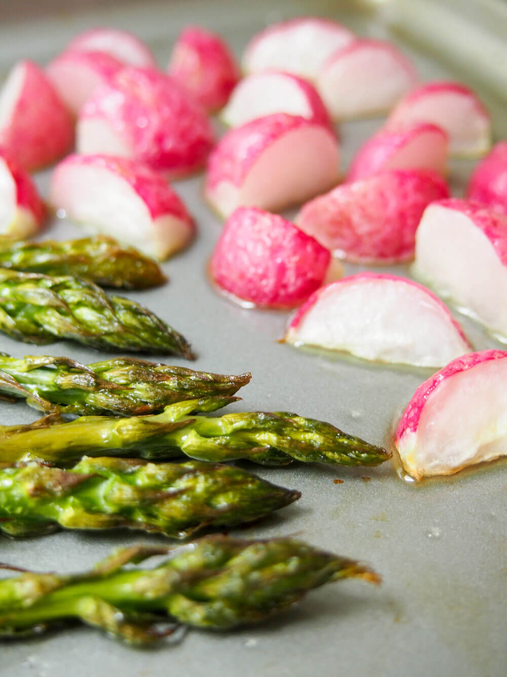 roasted asparagus and radishes on baking sheet