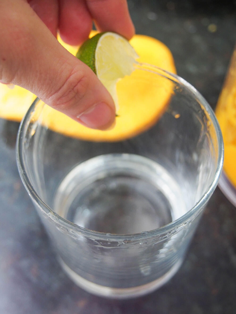 rubbing glass rim with lime for mango margarita