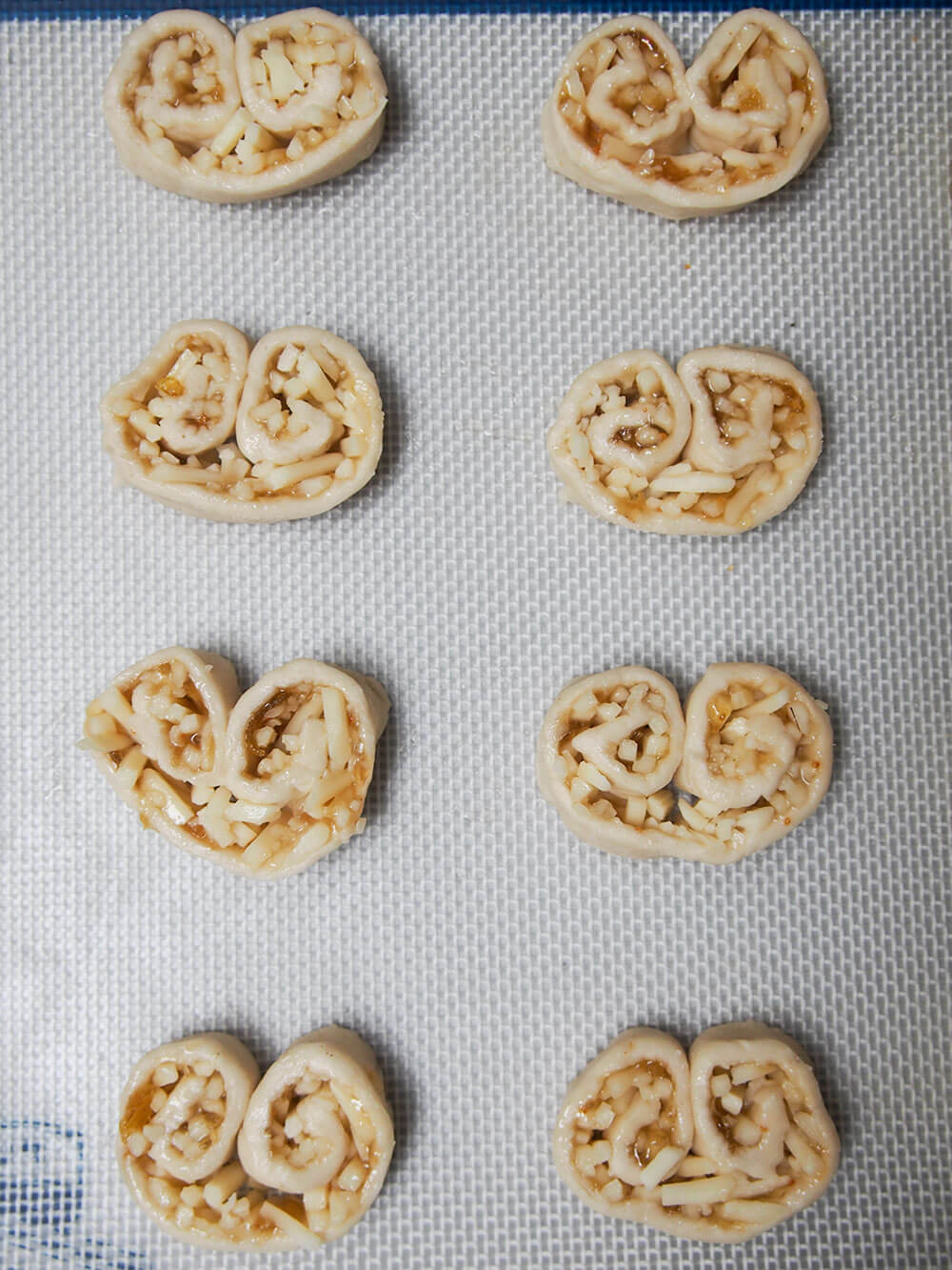 cheese and fig savory palmier slices on baking sheet ready to bake