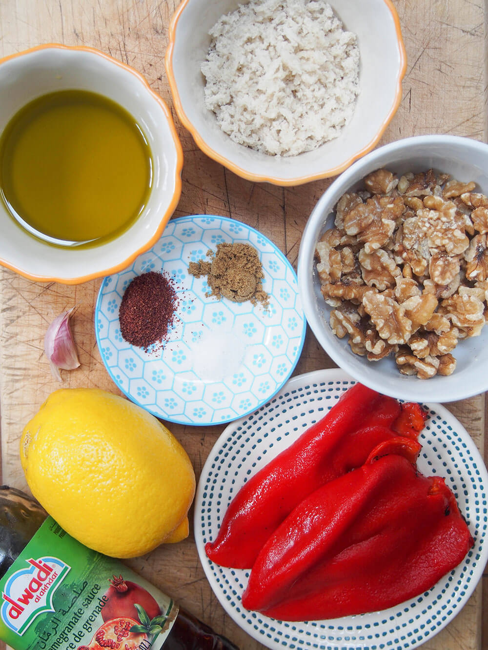 muhammara ingredients with some in dishes on chopping board