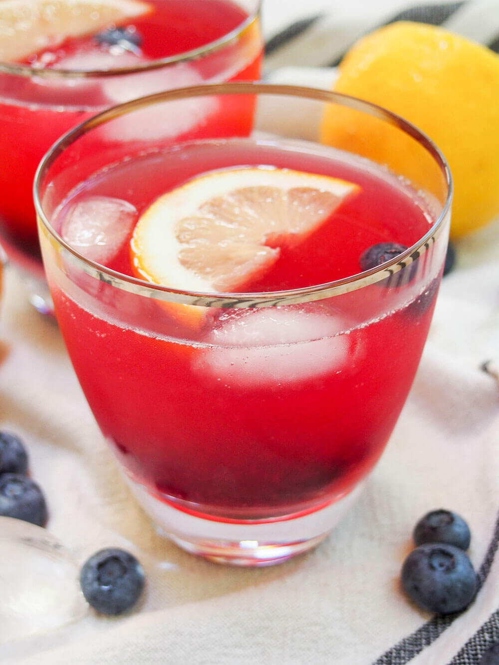 glass of blueberry lemonade with slice of lemon floating on top