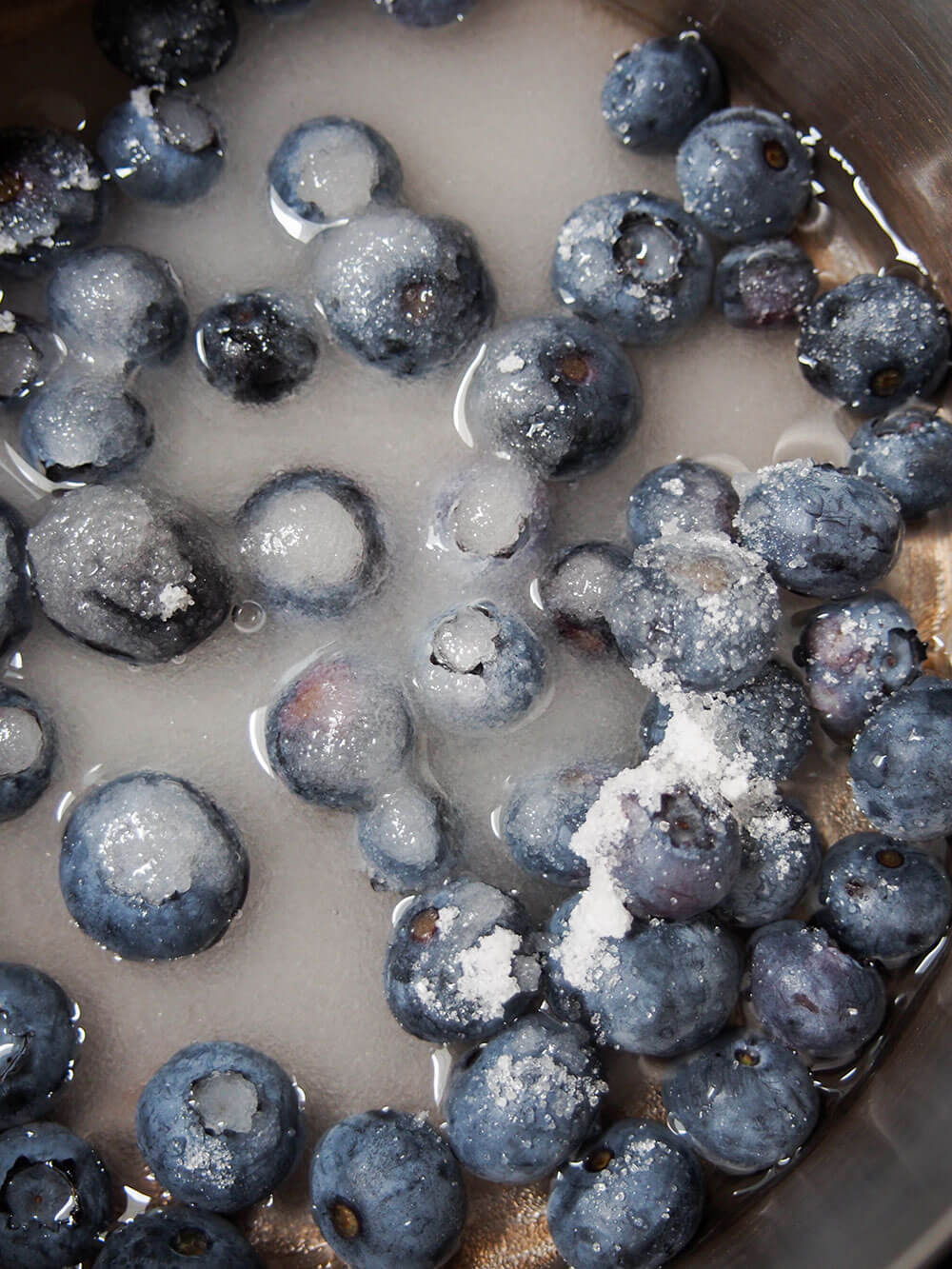 inrgedients to make blueberry simple syrup - blueberries, sugar and water - in pan