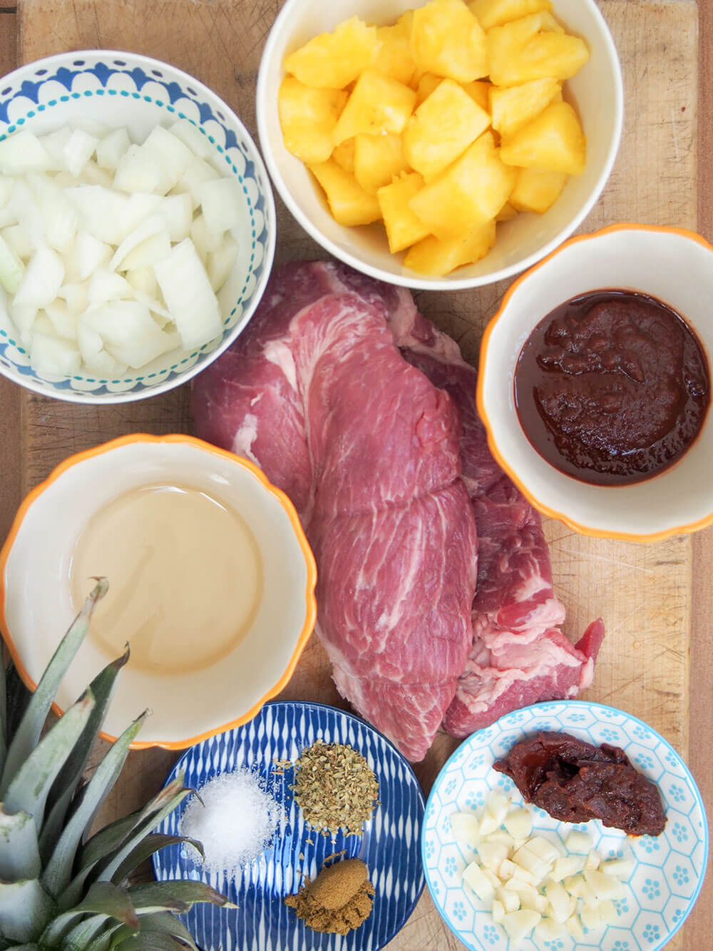 tacos al pastor ingredients in small bowls and on chopping board