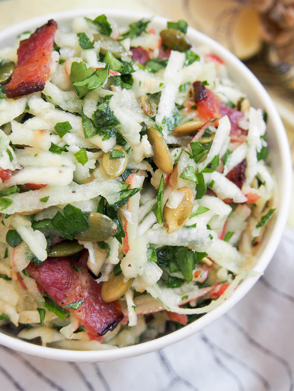 This apple celeriac salad is a delicious mix of flavors and textures. Easy to make, with some crunch, saltiness and sweet, it's perfect as a side or enjoy for lunch. close up of apple celeriac salad from overhead