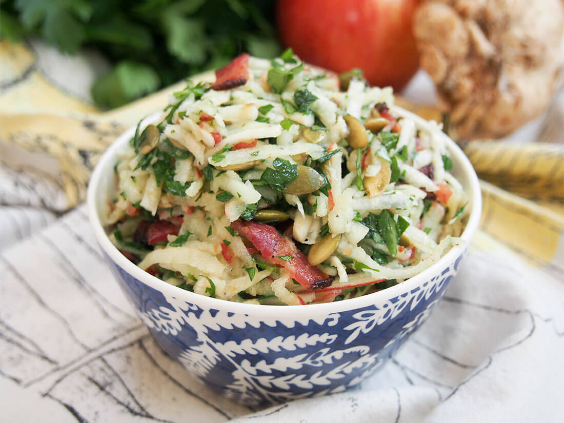 Apple celeriac salad is easy to make and packed with delicious flavor and crunch Apple celeriac salad in small bowl in front of some of ingredients