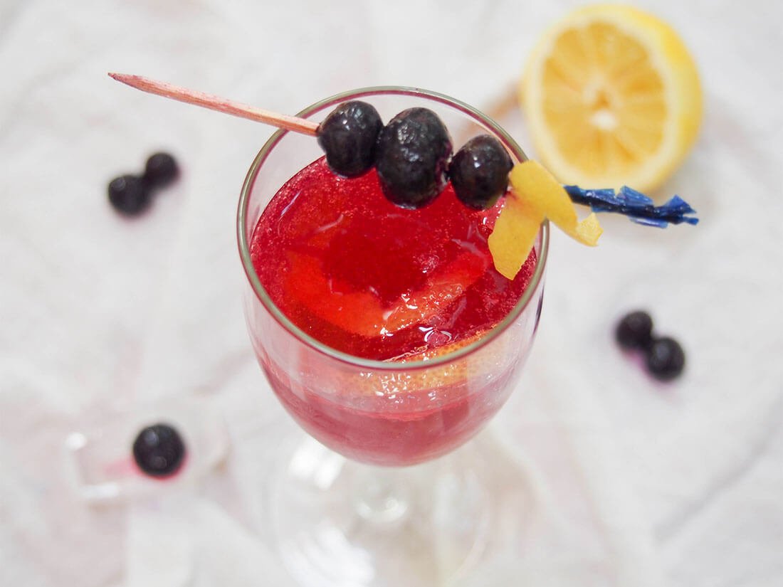 Blueberry French 75 cocktail with blueberry garnish