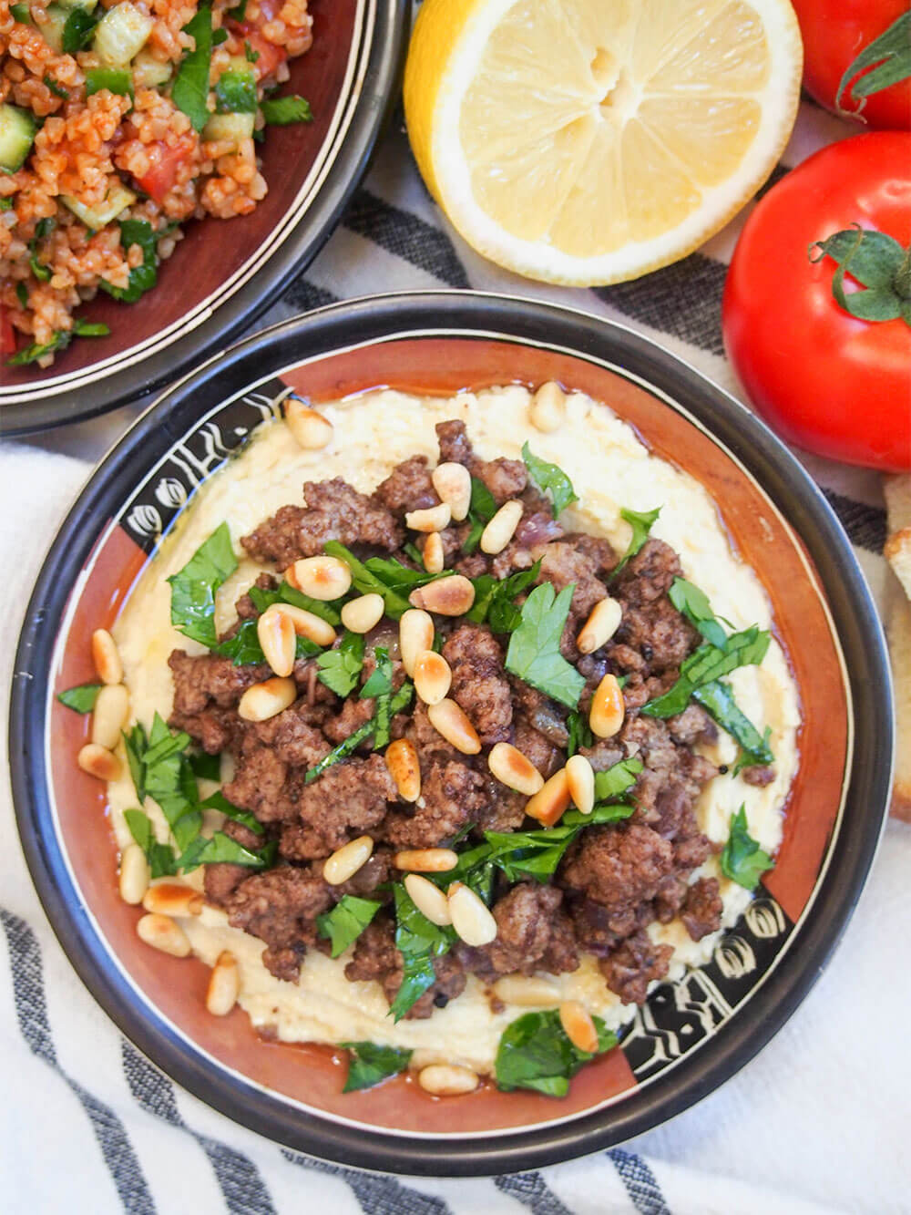 Hummus kawarma (hummus with lamb) in dish from overhead with lemon above
