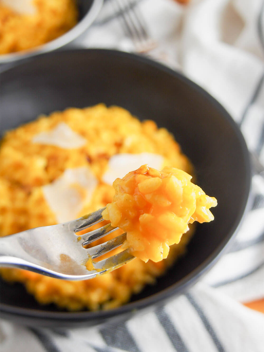 pumpkin risotto with some on fork held in front of bowl