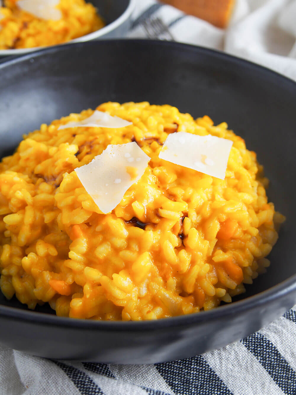 pumpkin risotto close up topped with drizzle of balsamic and shavings of parmesan