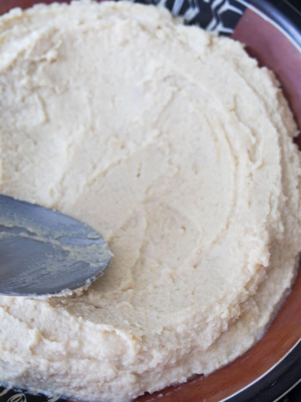 spreading out hummus in dish