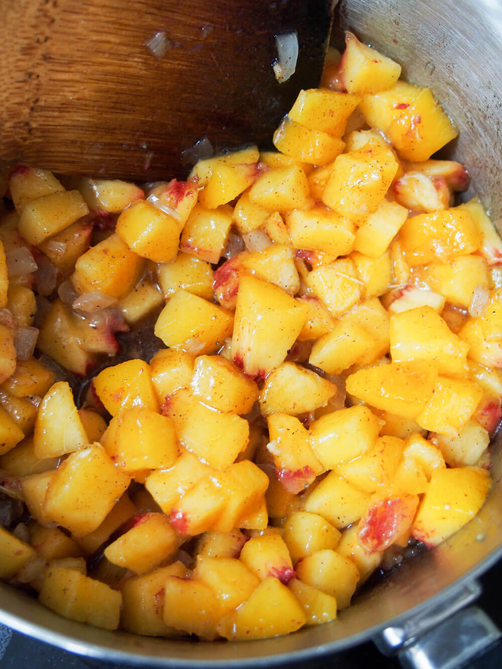 adding peaches to pan making peach chutney