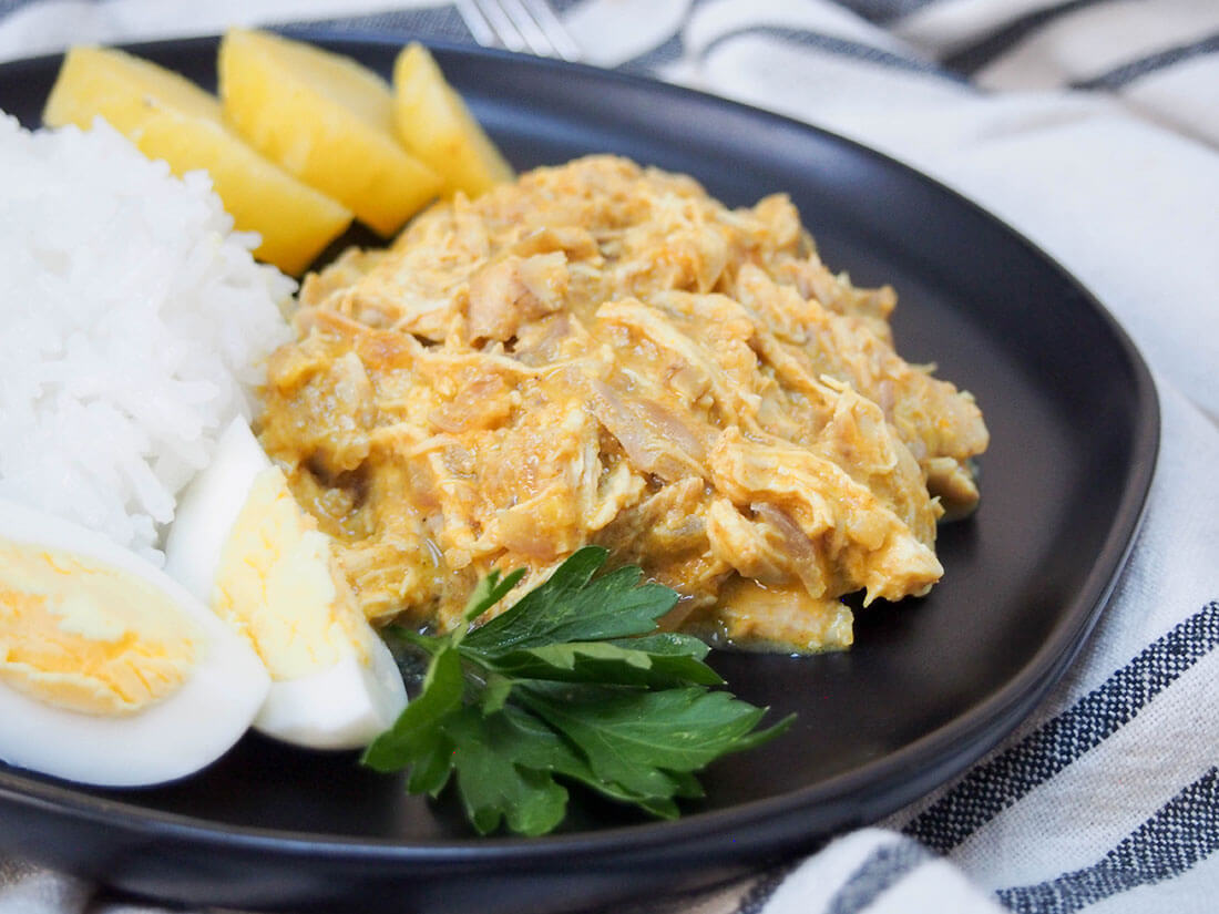 Aji de gallina (Peruvian chicken) served with traditional sides of rice, potato and egg Aji de gallina (Peruvian chicken stew) close up on plate with rice, potato and egg sides