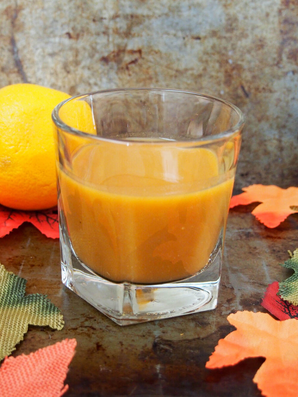 falling for orange: amaro pumpkin cocktail with orange behind