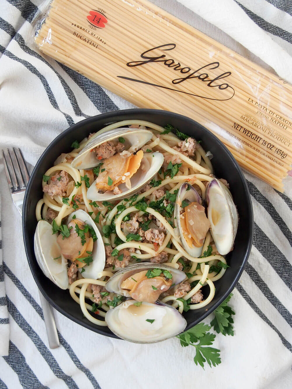 Pasta with clams and sausage with pack of pasta to side