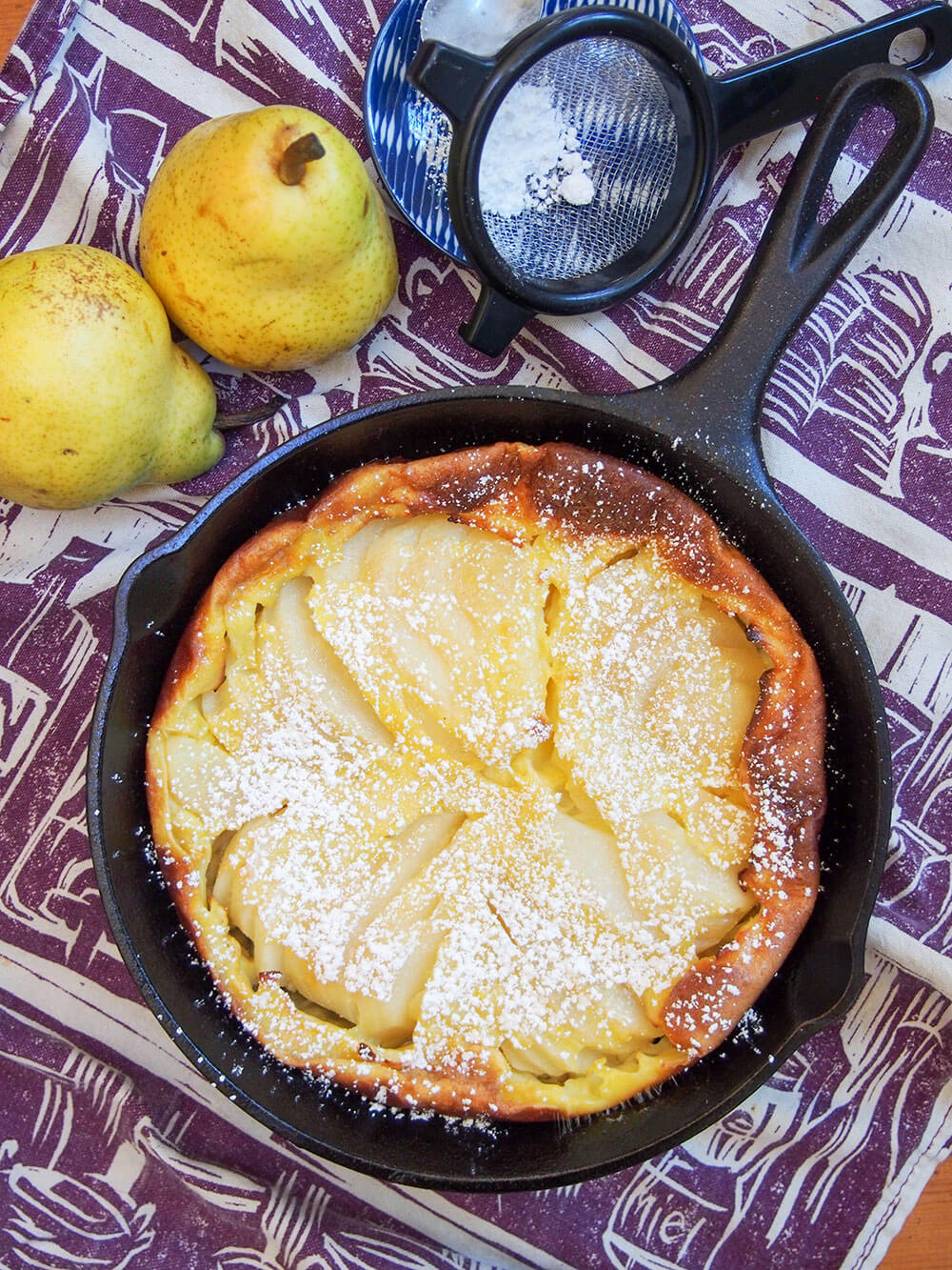 Pear clafoutis from overhead, dusted with sugar