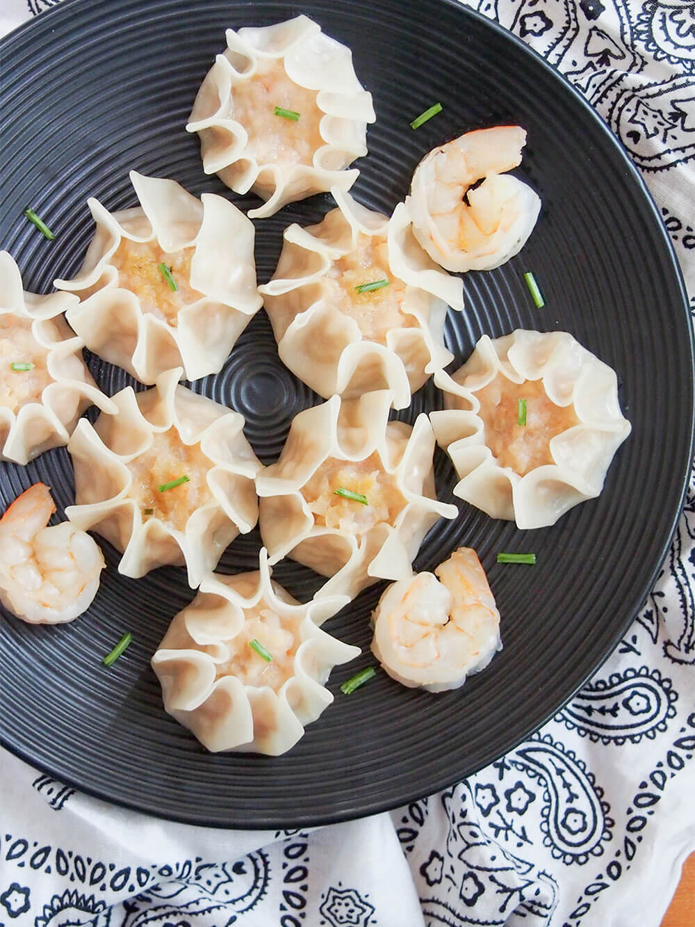 black plate with shrimp shumai viewed from overhead