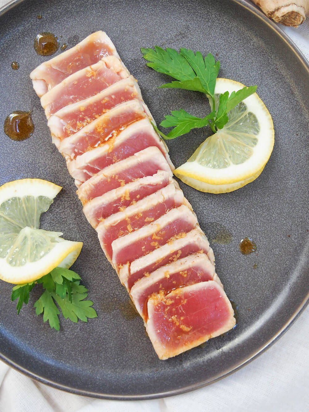 tuna tataki on plate from overhead with lemon slices decorating plate