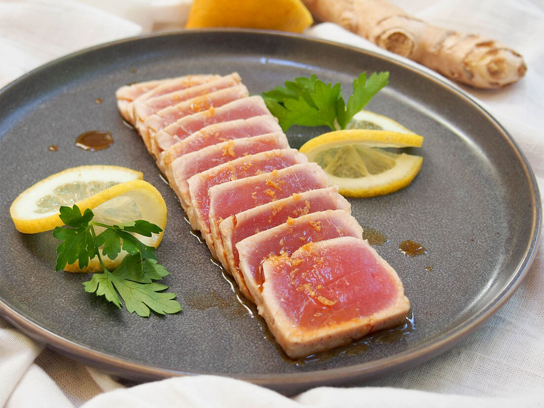 tuna tataki on plate with lemon as decoration