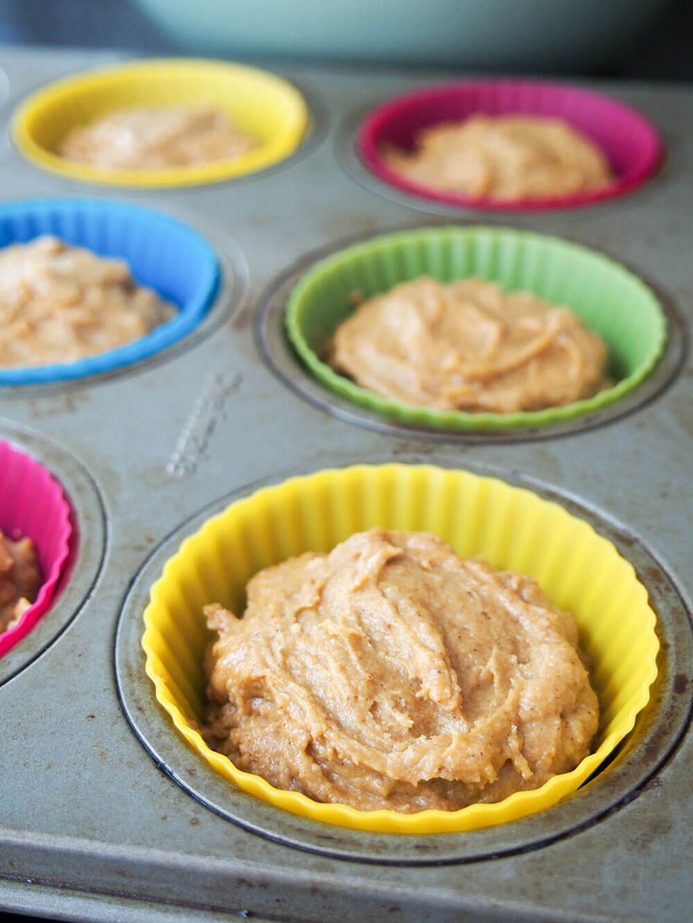 Pumpkin cupcake batter in cupcake linesrs ready to bake