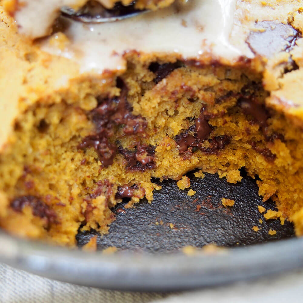 pumpkin skillet cookie up close showing melty chocolate chips.