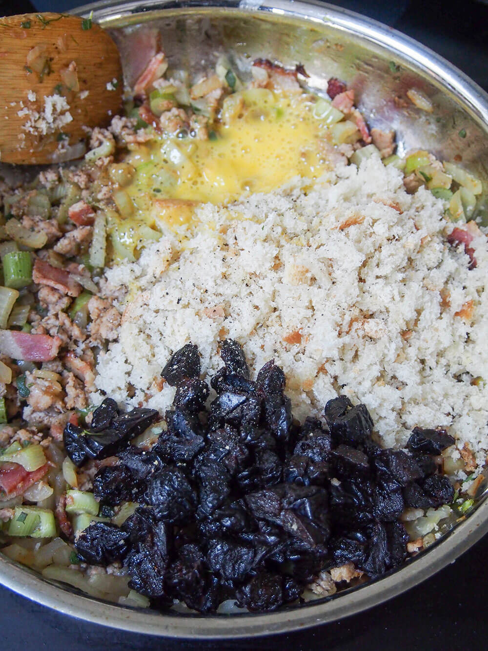 adding egg, prunes and breadcrumbs to stuffing mixture