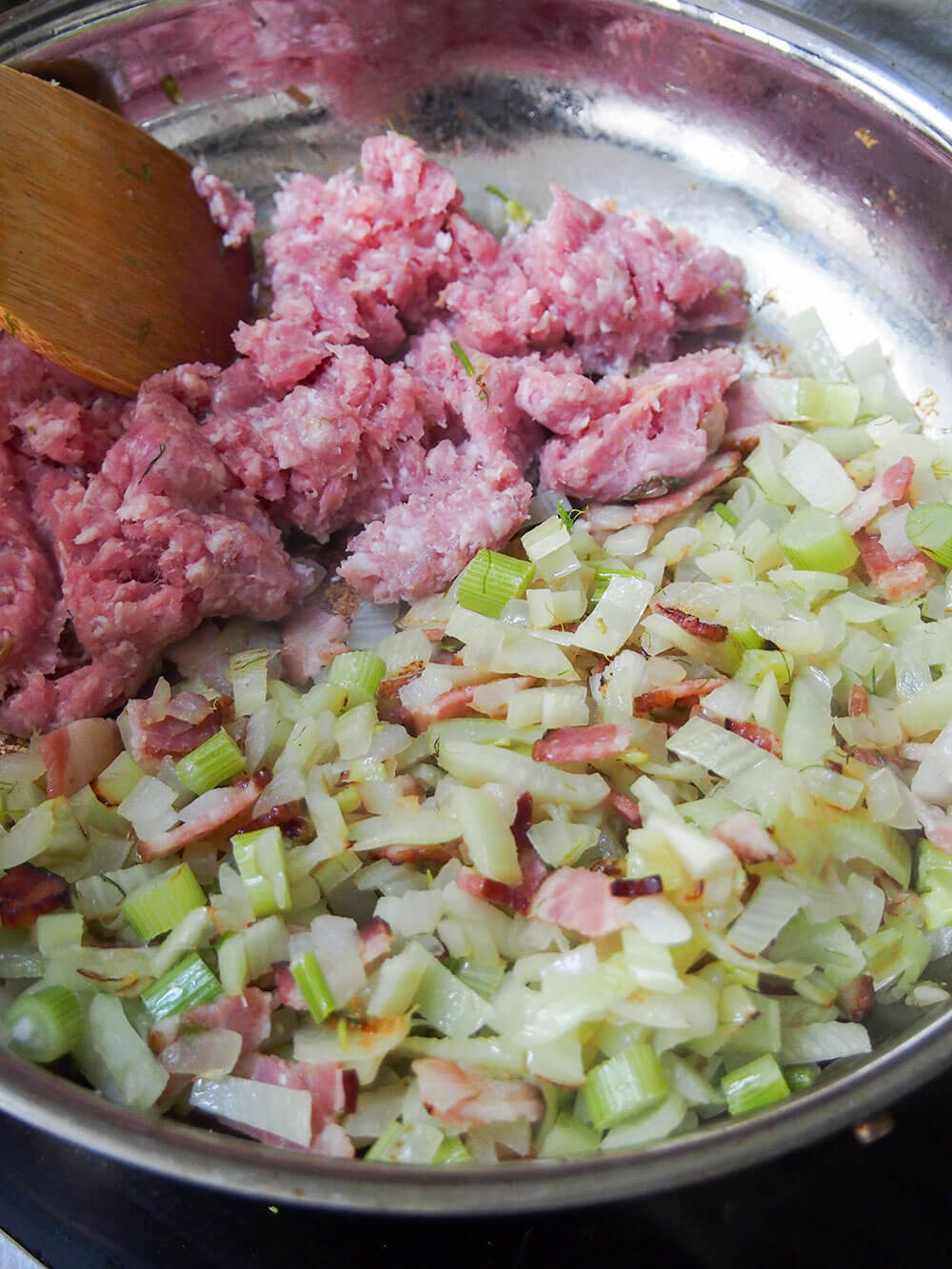 adding pork to fennel bacon mixture in skillet