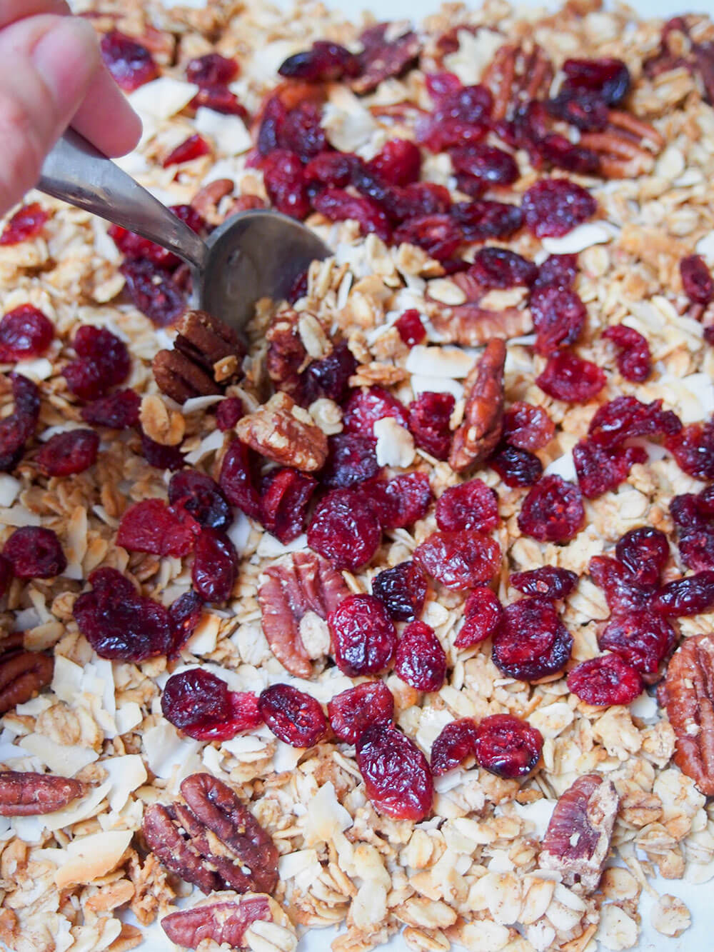 adding cranberries to homemade granola