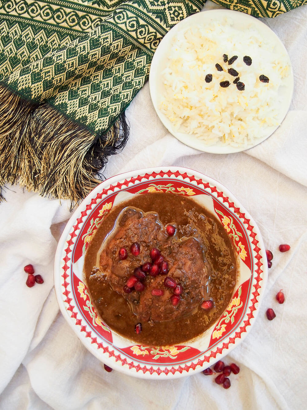 bowl of fesenjan with bowl of rice to side from overhead
