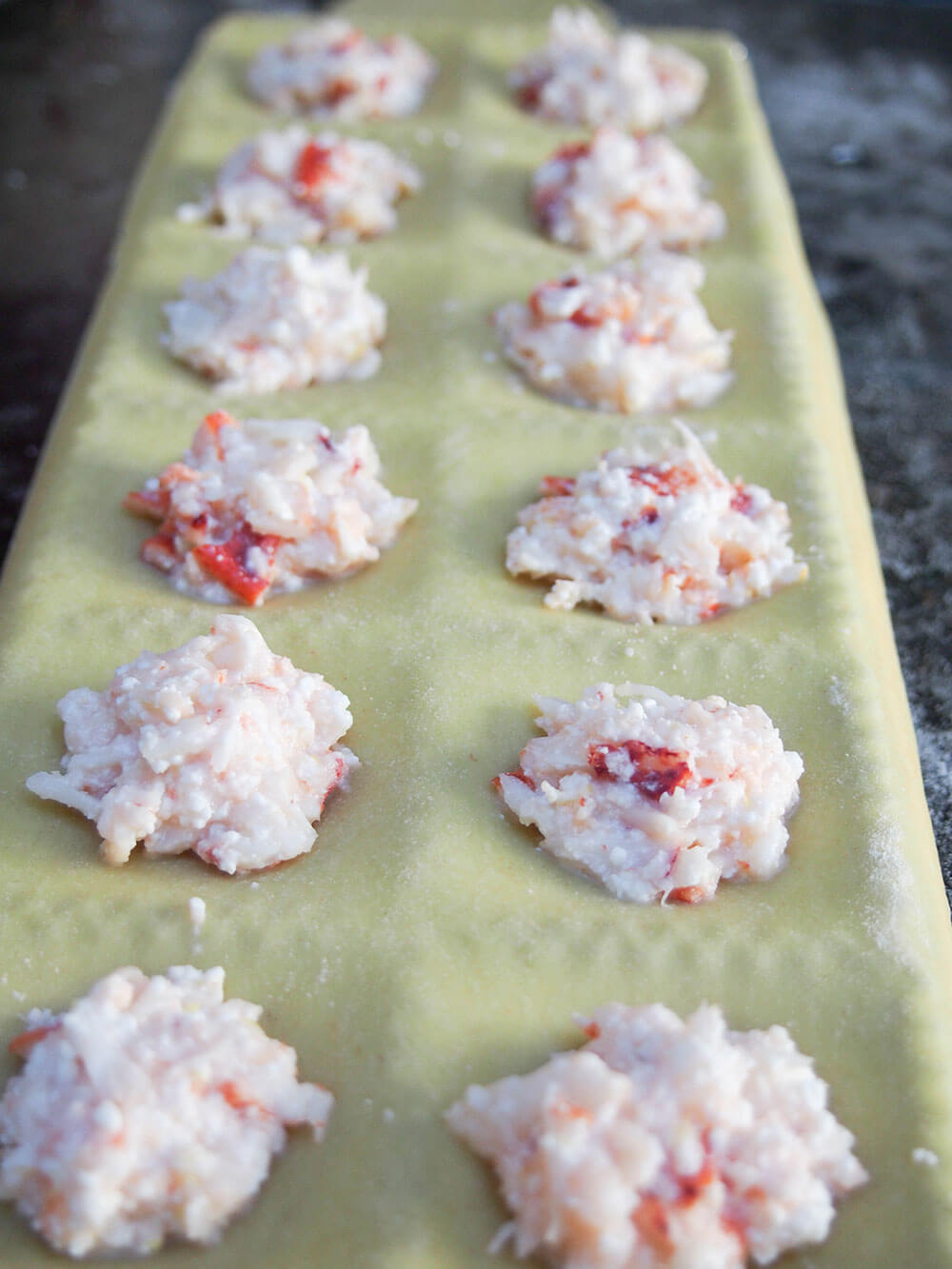 filling lobster ravioli mould - bottom layer of pasta topped with filling