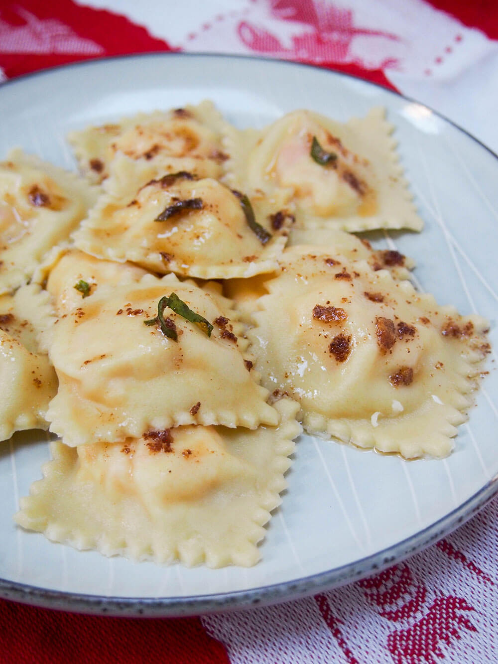 lobster ravioli topped with sage brown butter on plate