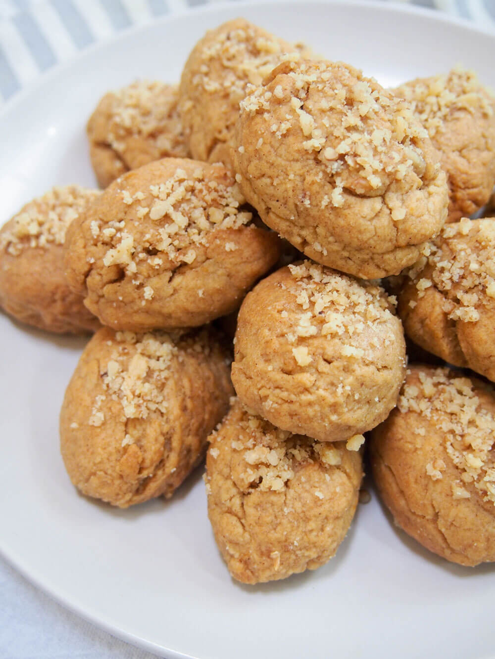 Melomakarona are a classic Greek cookie, with a gently spiced flavor in the dough and finished by dipping them in honey syrup. They're tasty little bites! Stack of melomakarona (Greek honey cookies) close up