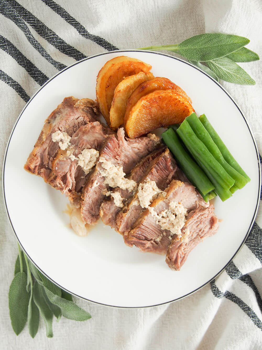 Milk-braised pork (maiale al latte) on plate with sides viewed from overhead