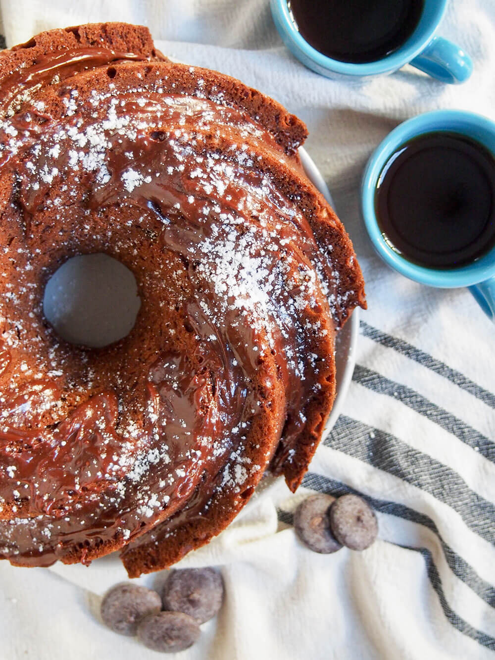 This sour cream mocha cake is tender and delicious. It's easy to make and perfect for just about any occasion (especially with a cup of coffee, of course). sour cream mocha cake from overhead with coffee cup to side