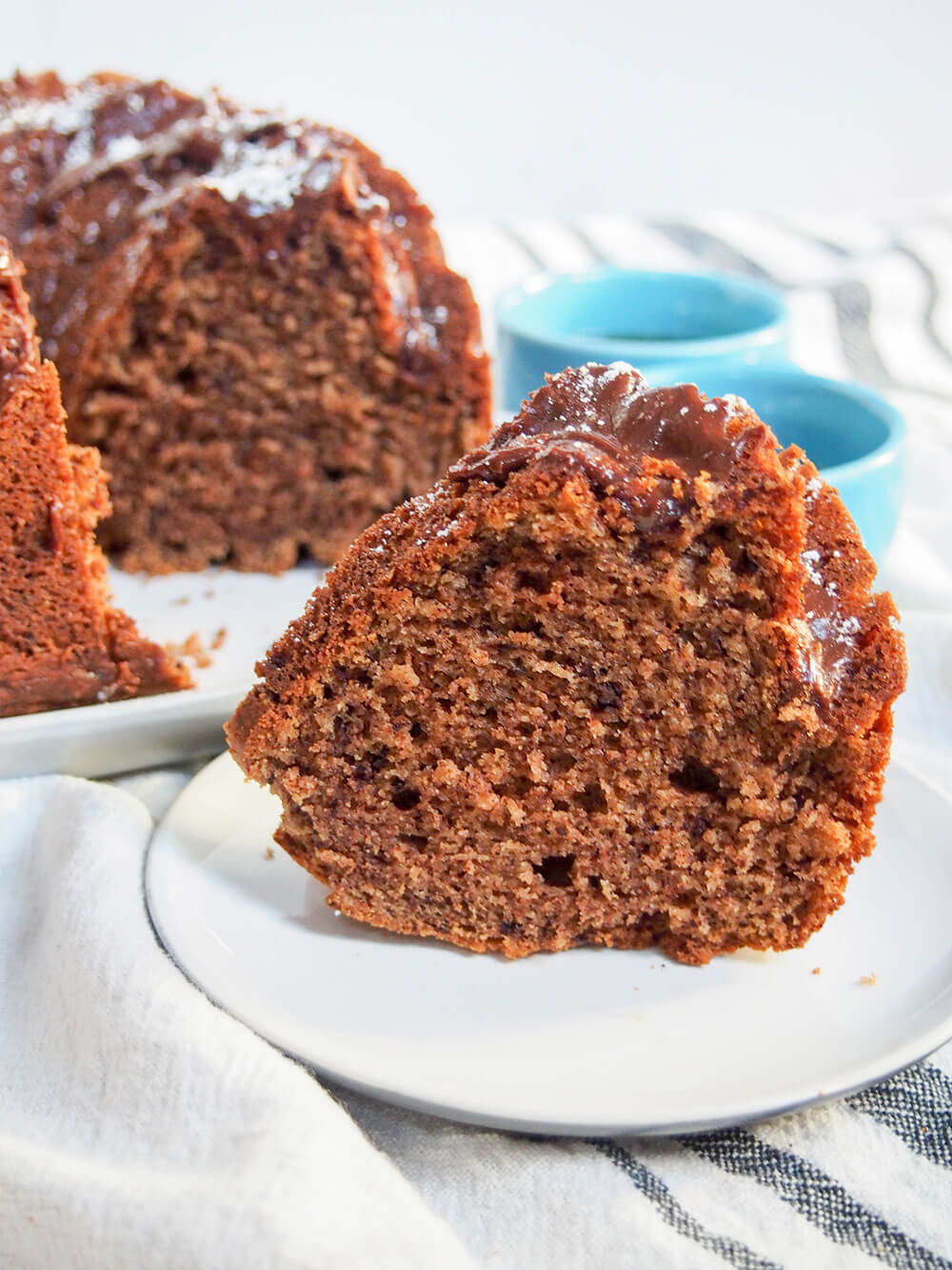 This sour cream mocha cake is tender and delicious. It's easy to make and perfect for just about any occasion (especially with a cup of coffee, of course). slice of sour cream mocha cake in front of rest of cake