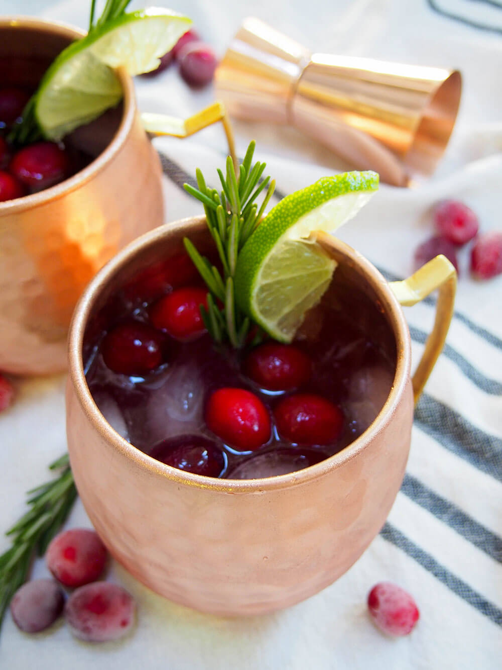 This cranberry Moscow mule is a simple seasonal twist on a classic cocktail, that can also easily be made as a mocktail. Perfect for a festive party! cranberry Moscow mule close up on mug in front