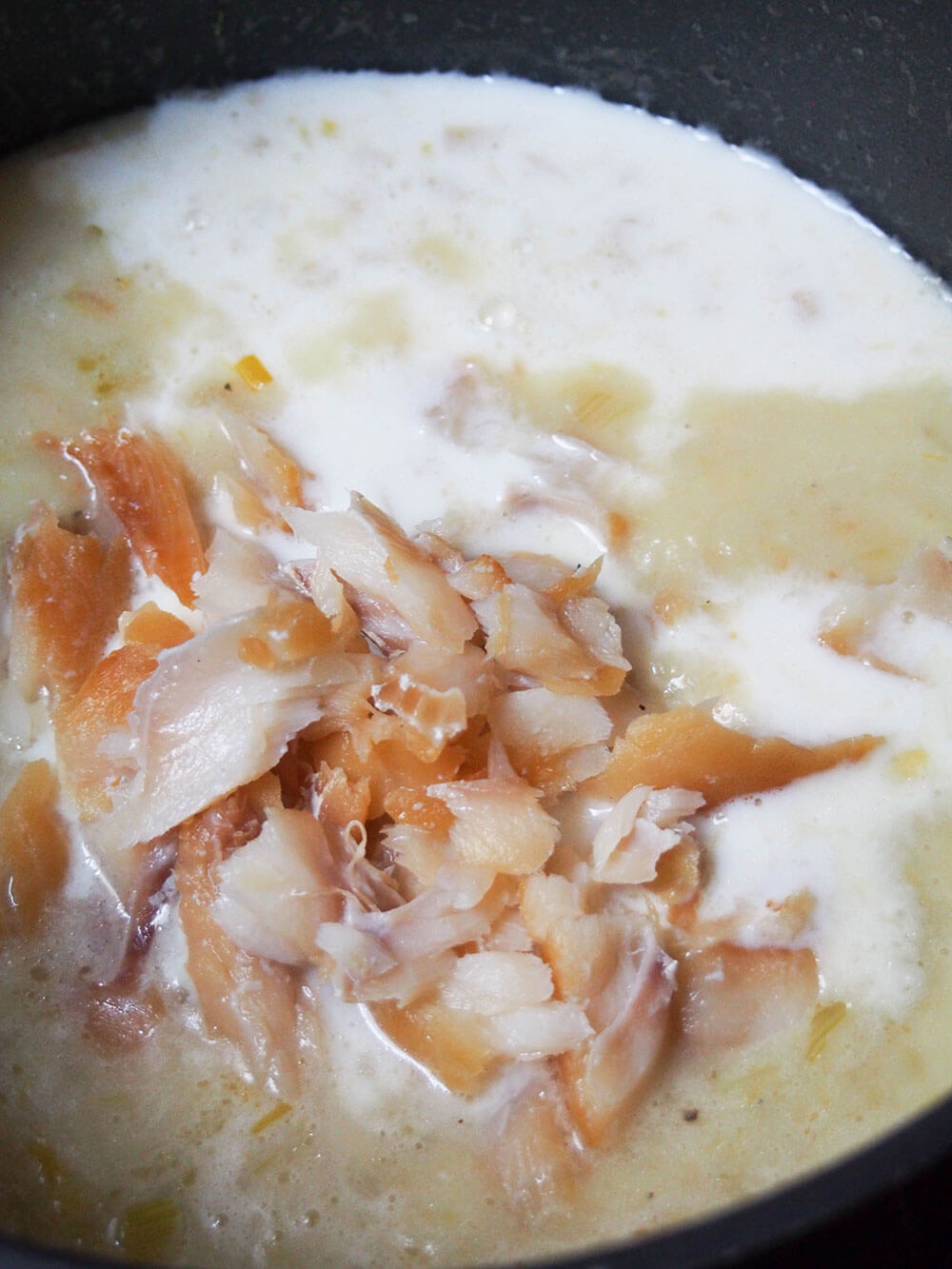 adding milk and fish to soup base