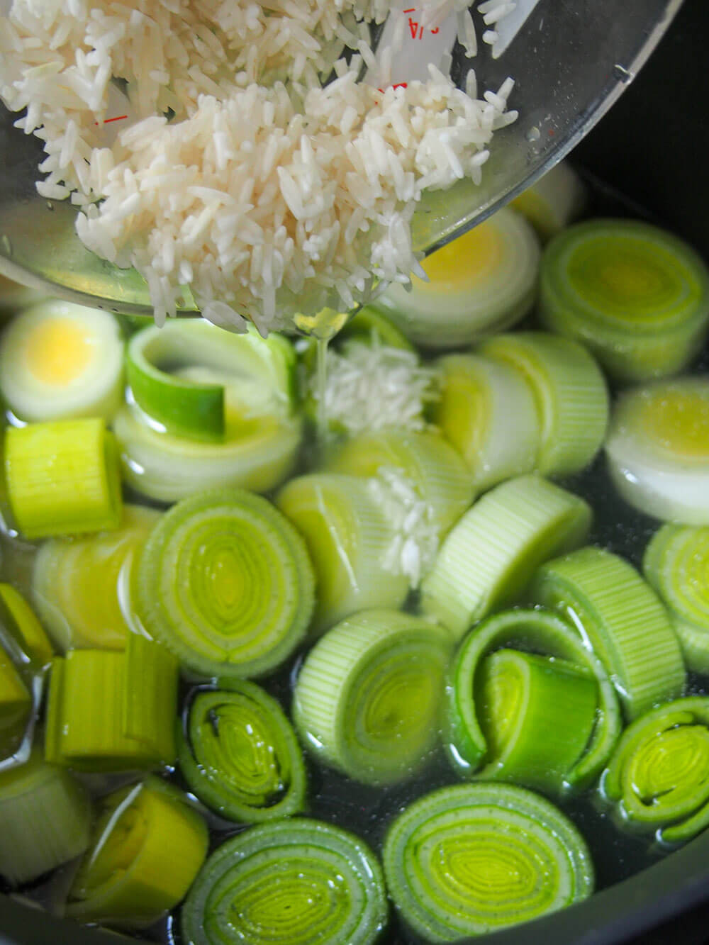 adding rice to stock and leeks