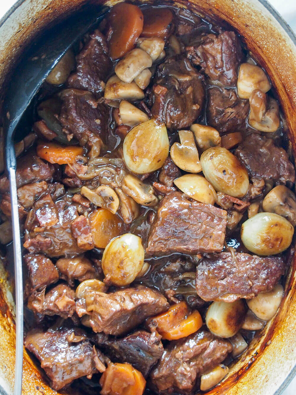 Beef bourguignon in Dutch oven from overhead with spoon to side