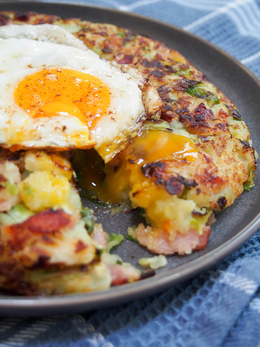 bubble and squeak cut open with egg on top dripping inside