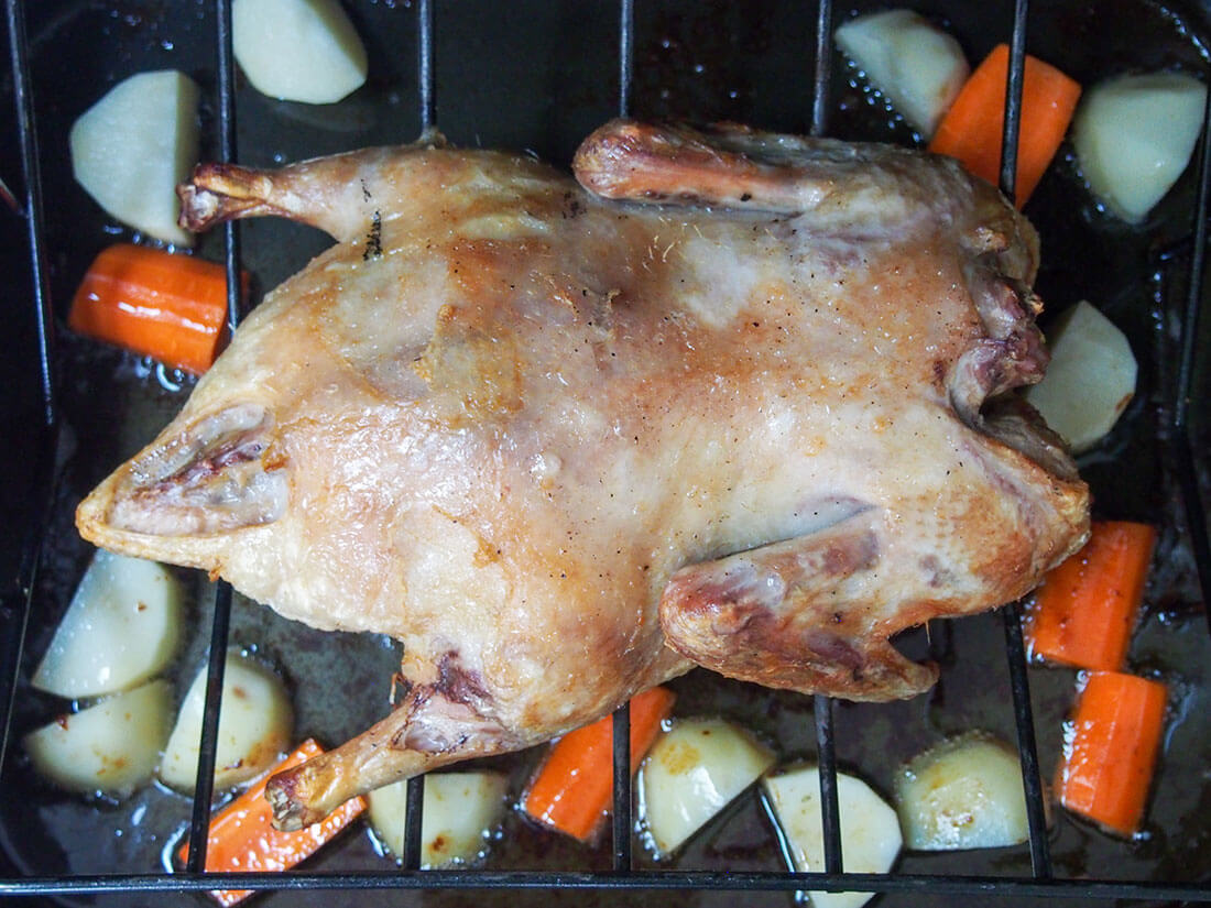 adding vegetables under roast duck