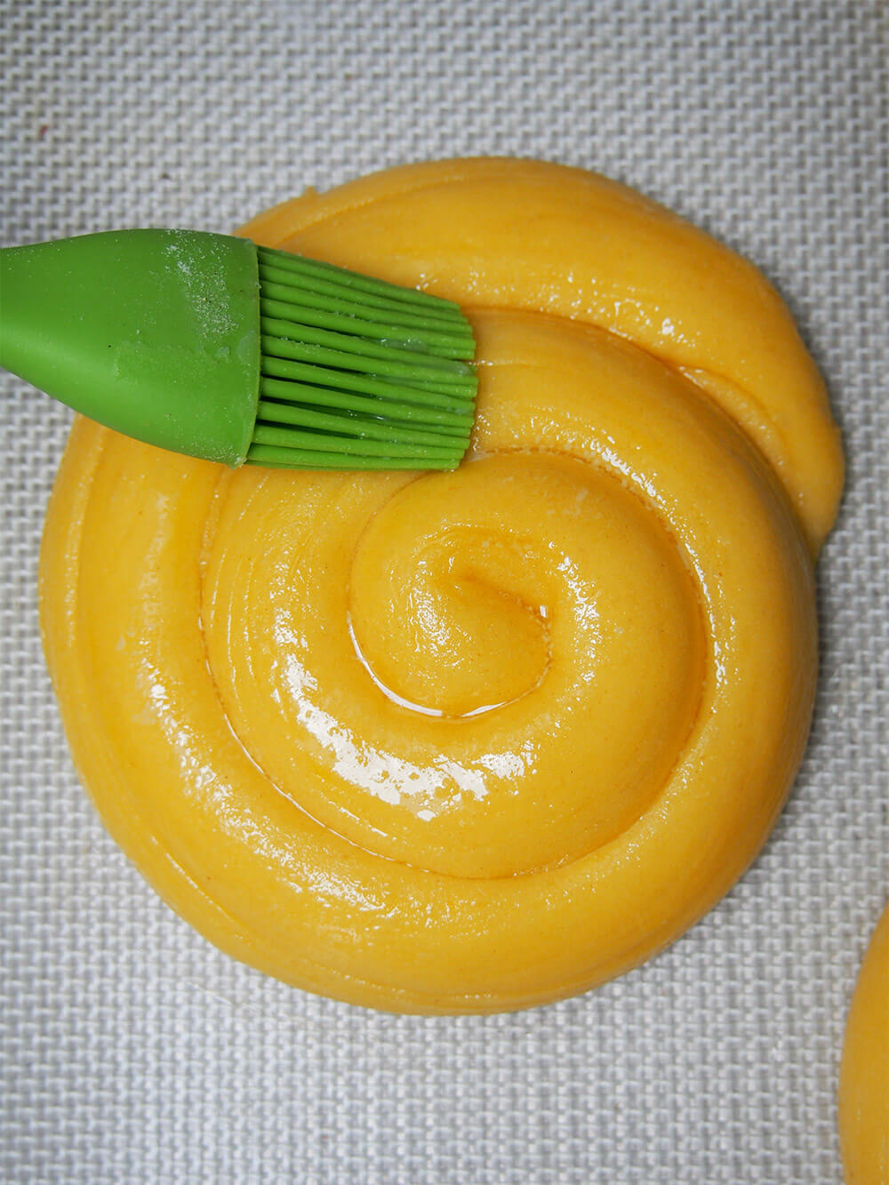 brushing butter on bread before baking
