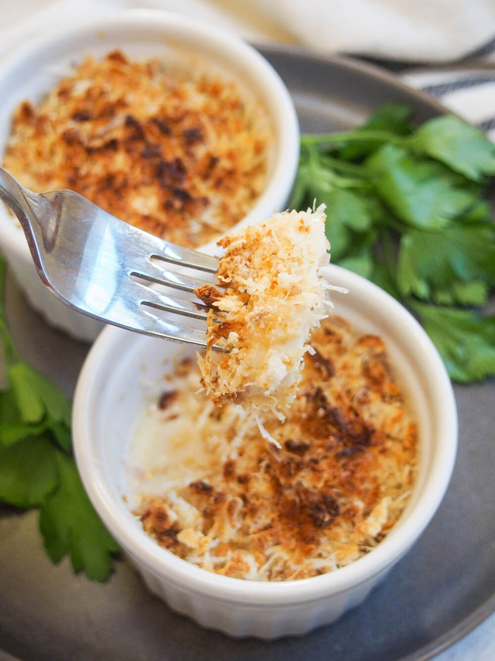 Coquille St Jacques is a scallop gratin with the scallops wrapped in a cream & wine sauce with a crisp topping. It's elegant and delicious - make someone feel special and make it soon! forkful of Coquille St Jacques (scallop gratin)