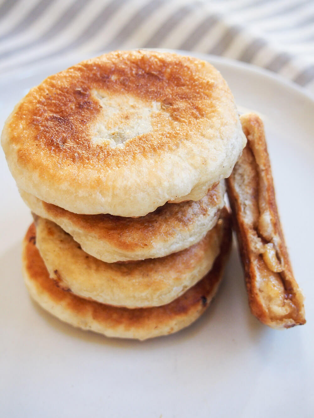 stack of hotteok, Korean sweet pancakes with one bitten into to the side