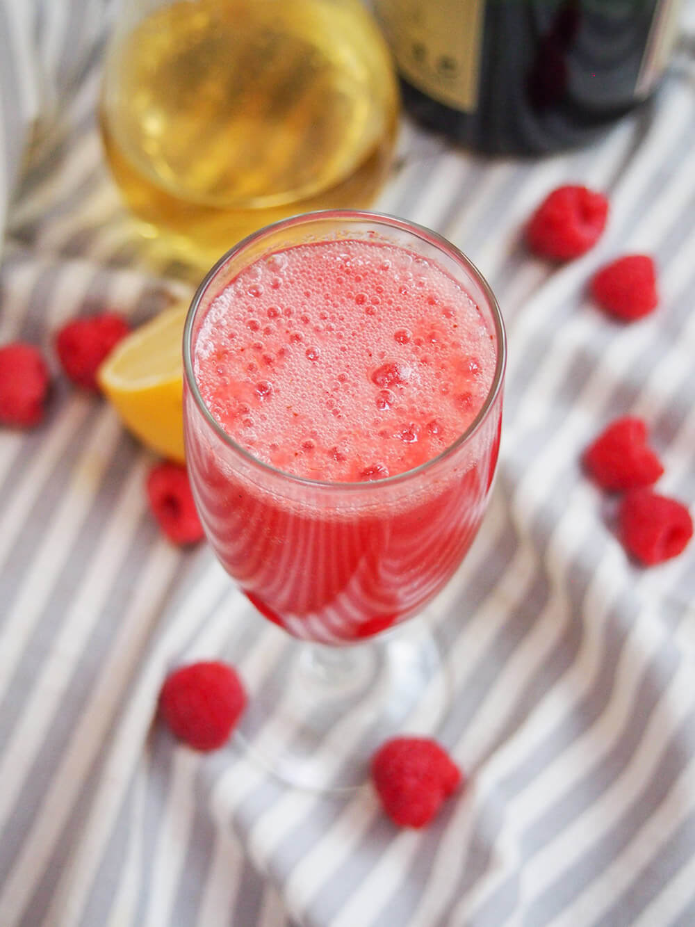 lemon raspberry bellini with bubbles on top of glass