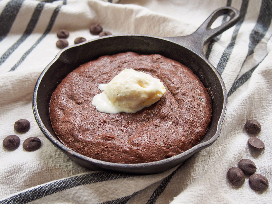 mini skillet brownie with ice cream on top and chocolate chips around skillet