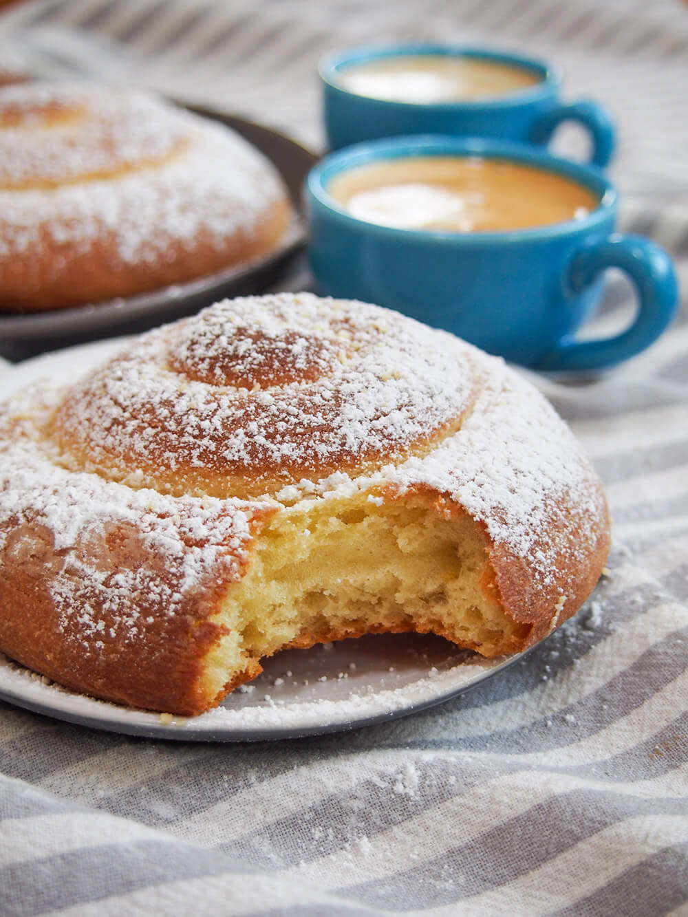 Pan de Mallorca (Puerto Rican sweet rolls) with bite taken from roll