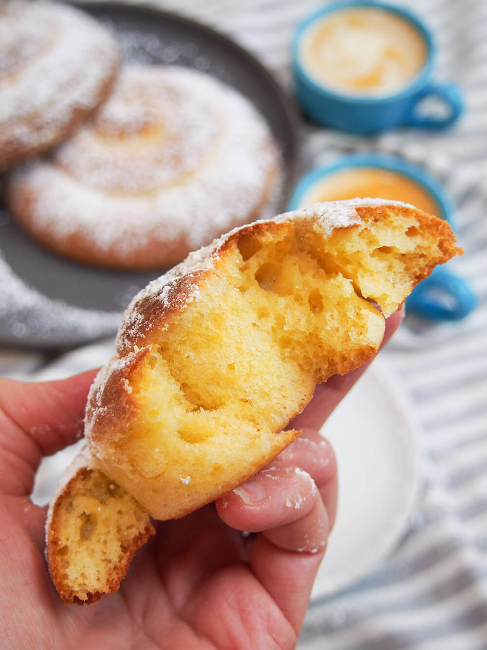 Torn pan de Mallorca (Puerto Rican sweet roll) in hand