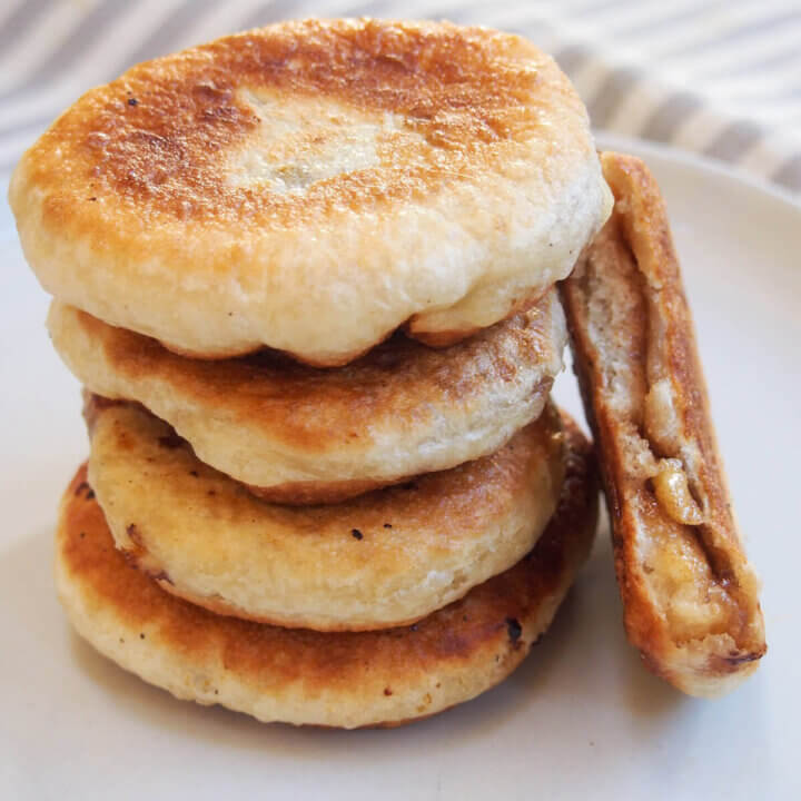 hotteok Korean sweet pancakes in stack with one bitten resting to side