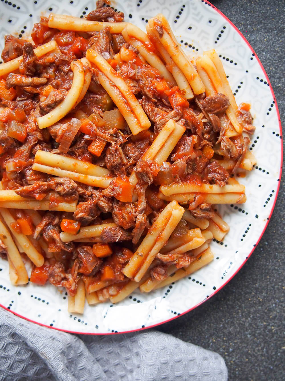 lamb ragu pasta close up showing part of plate
